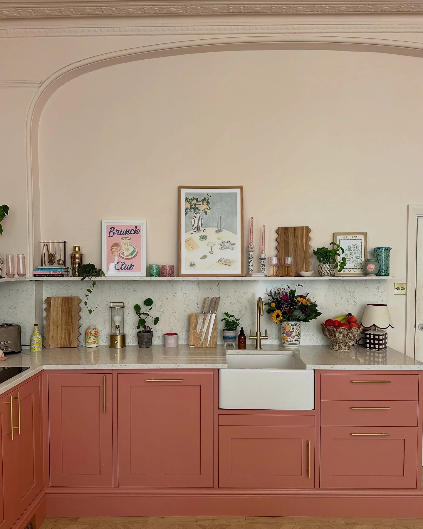 Coral Cabinets with Thin Gold Hardware Create an Inviting Kitchen