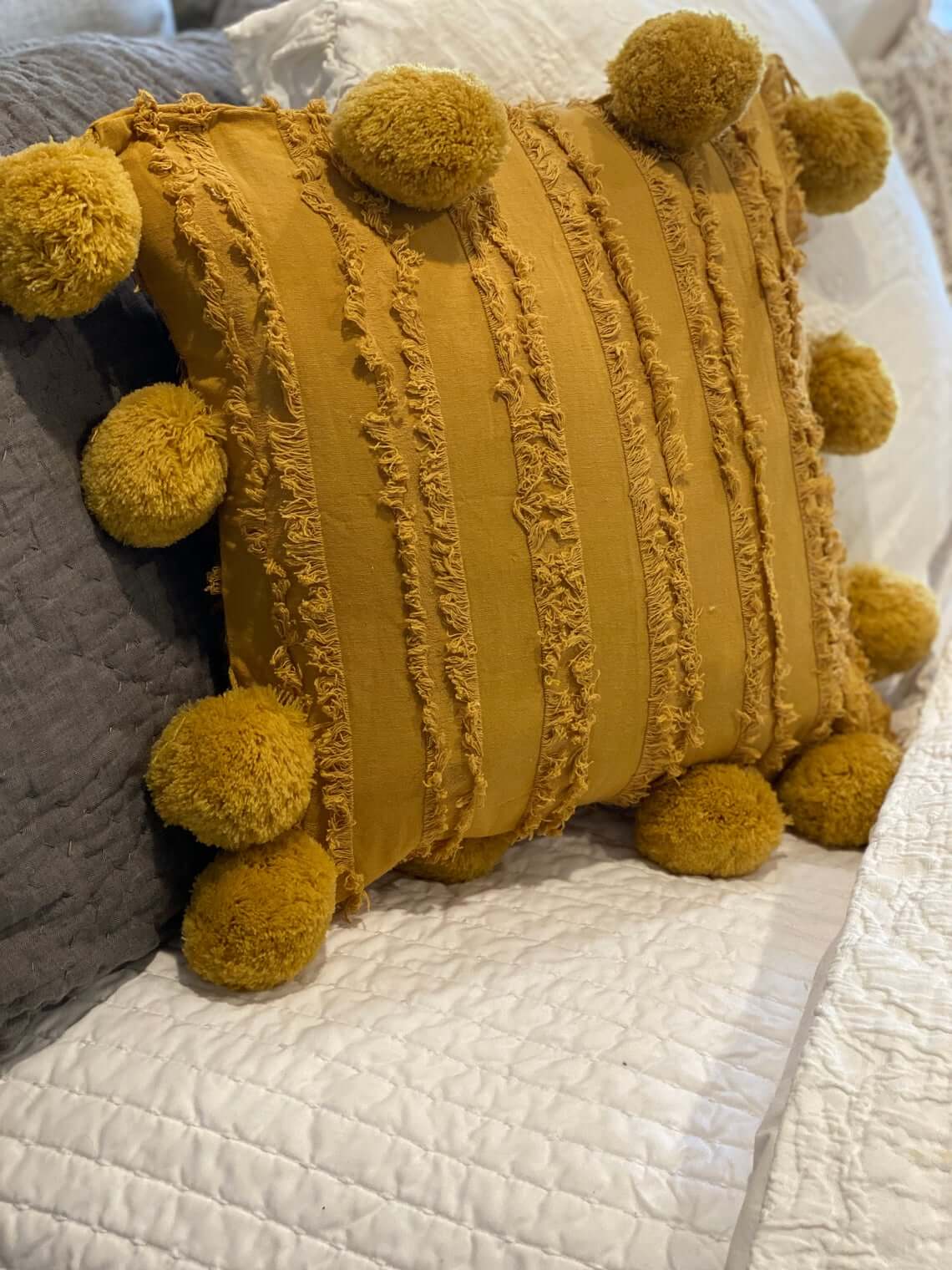 Mustard Pom-Pom Pillow Adds Playful Texture