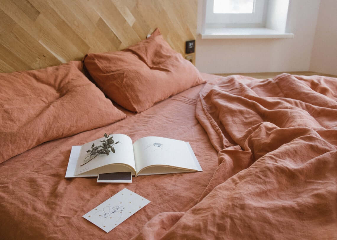 Terracotta Linen Bedding With A Natural Wood Headboard