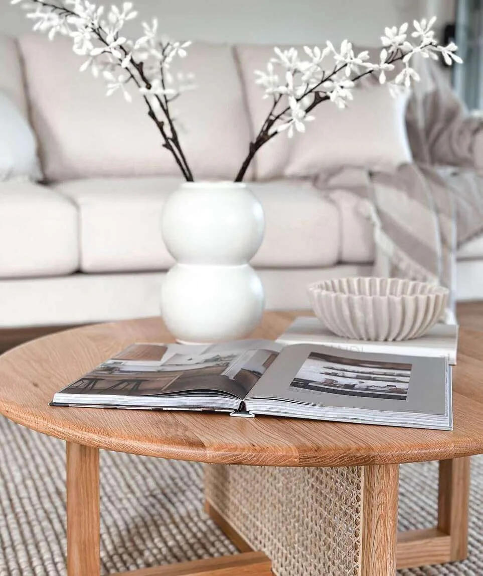 Stacked Books Support a Sculptural White Vase