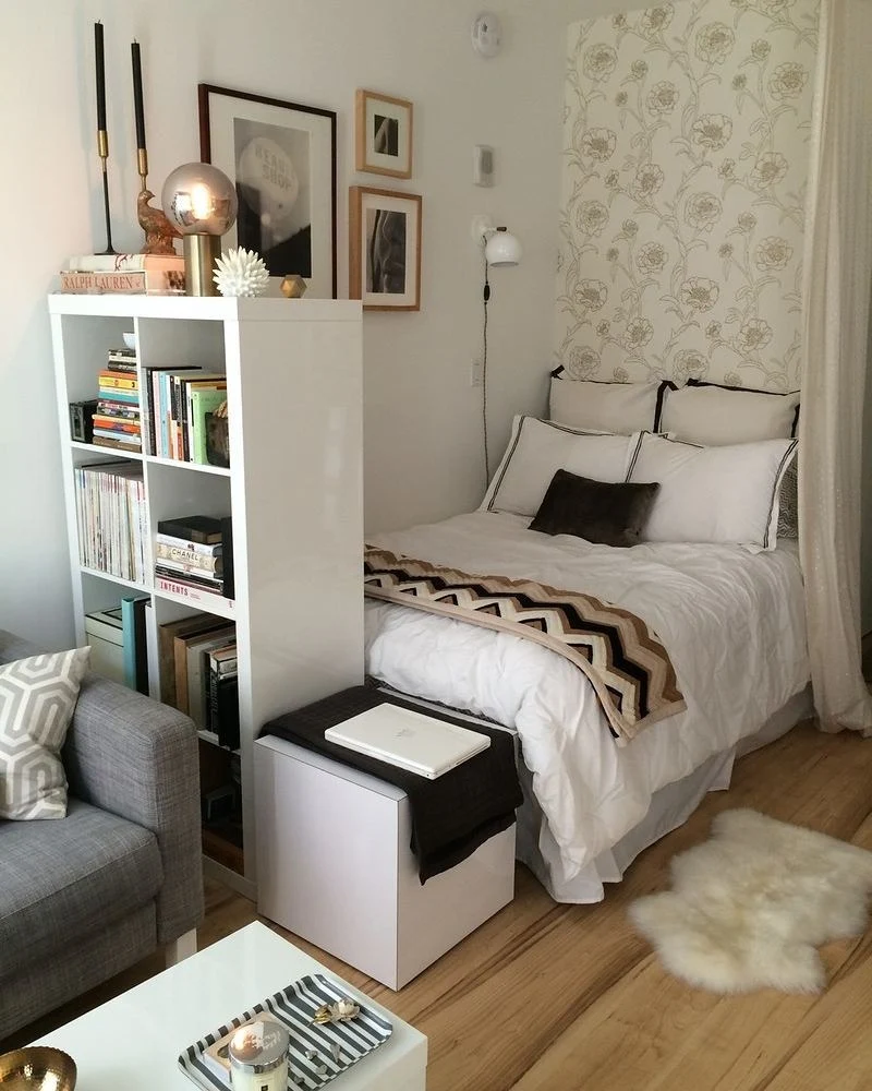 Tall bookshelf creates a cozy nook beside the bed