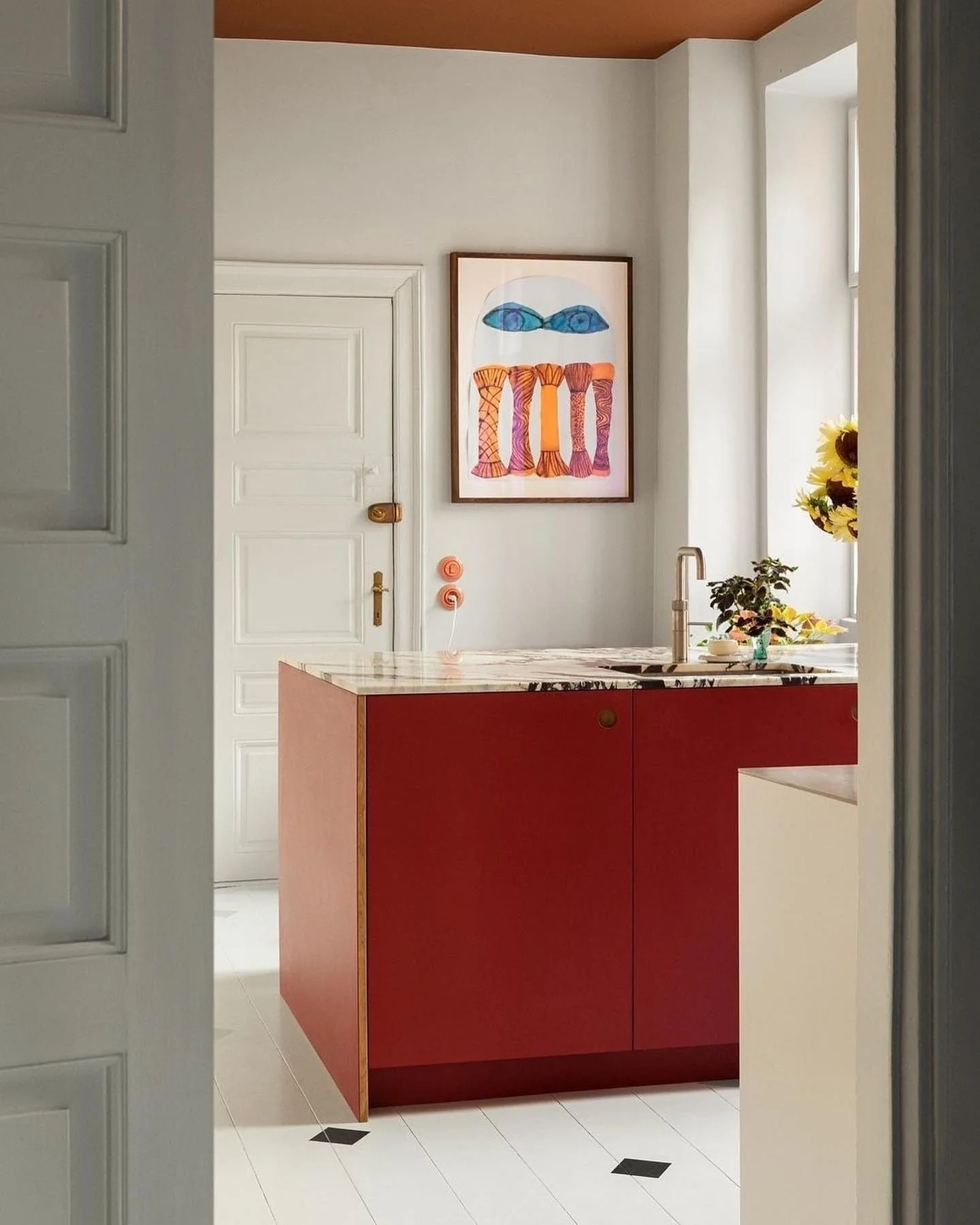 Striking Red Island with Marble Countertop and Brass Knobs