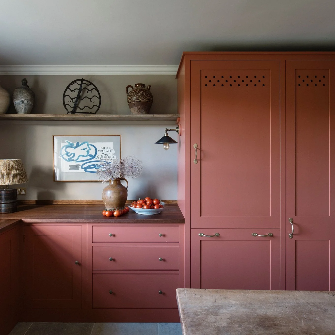 Subtle Texture: Deep Red Cabinetry with Perforated Upper Doors