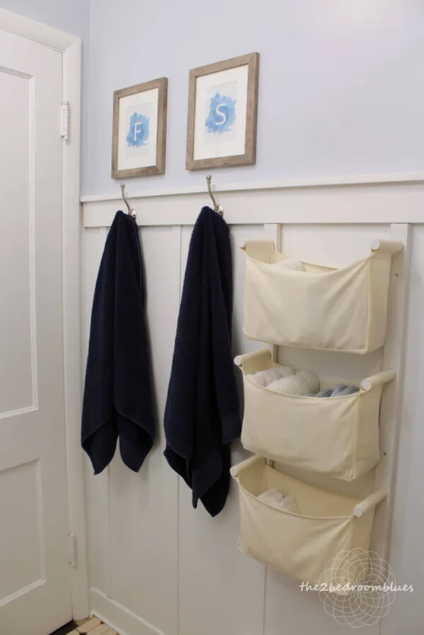 Cream fabric wall pockets for storing folded towels and linens