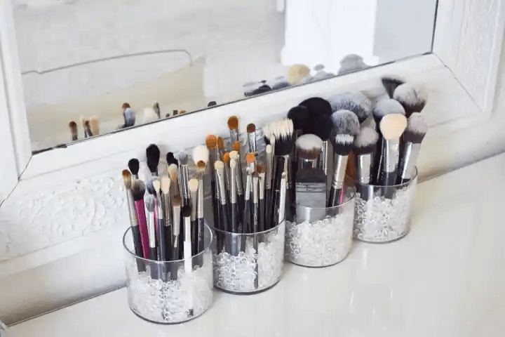 Clear Cylindrical Holders Filled With Beads for Brush Storage