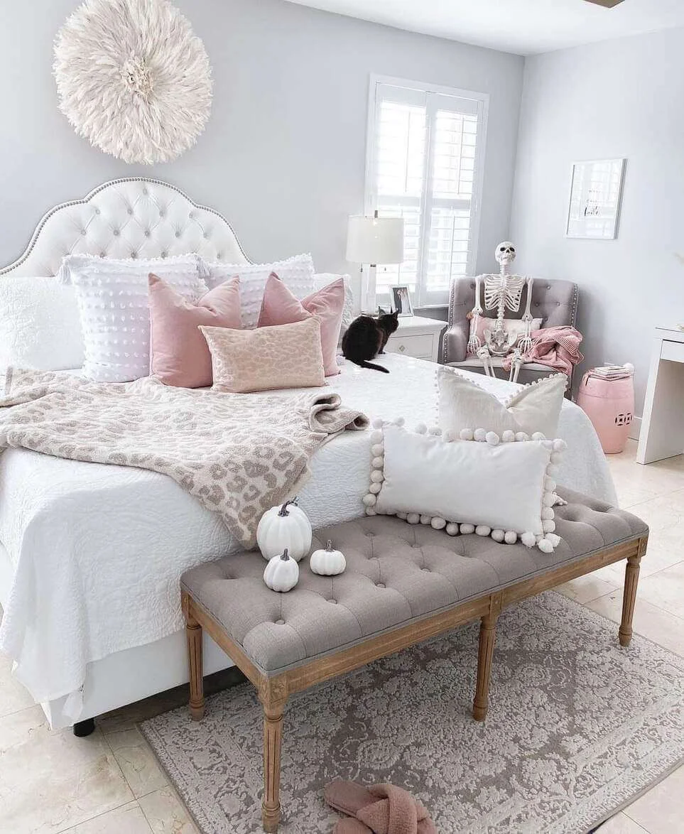 Tufted bench with carved wood legs anchors the bed