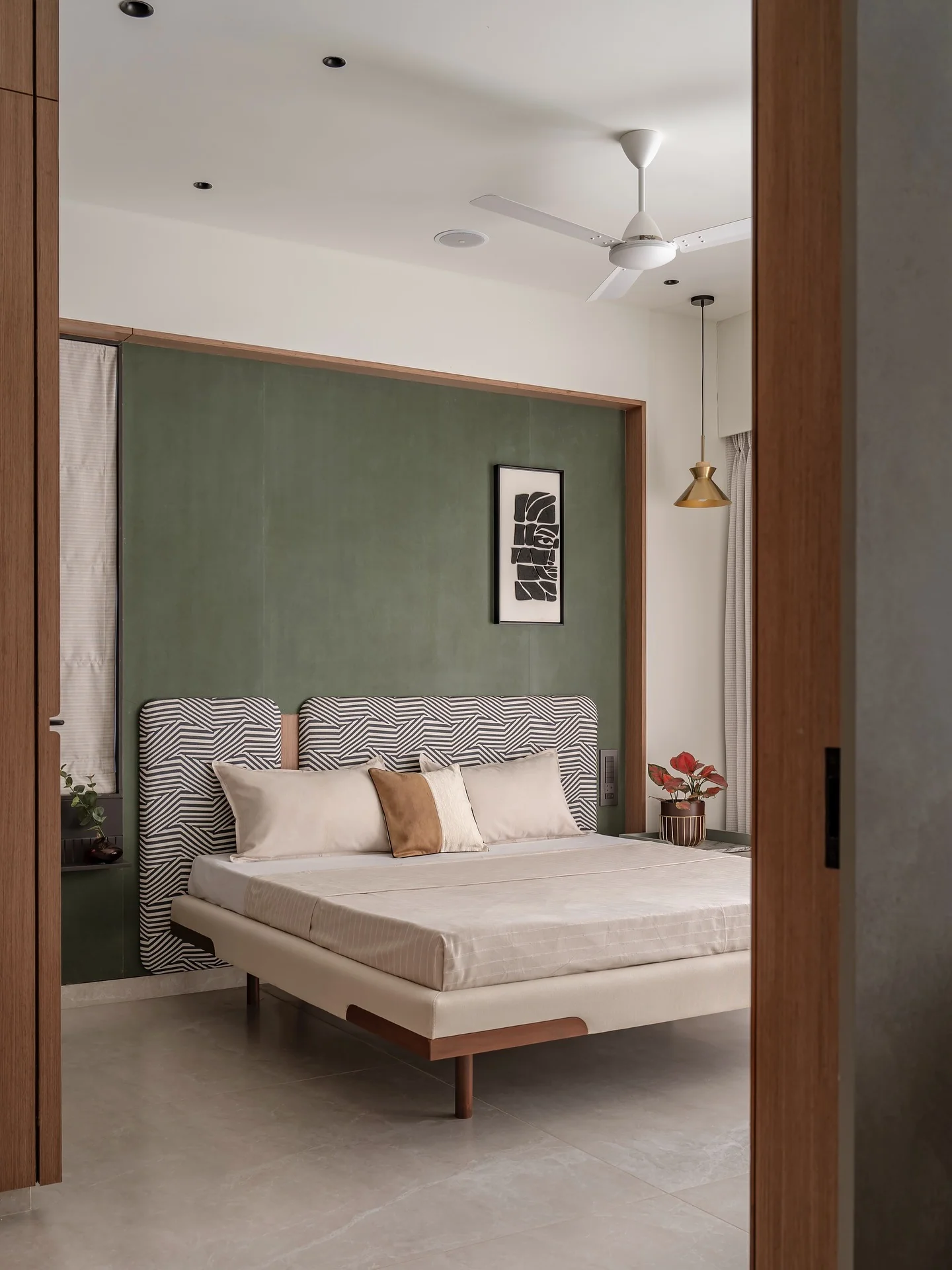 Graphic Headboard Design Contrasts with Green Walls