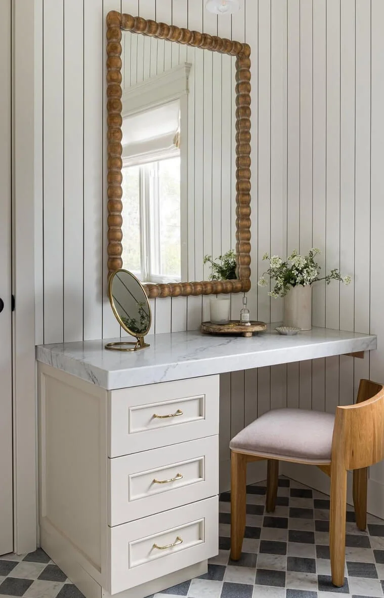Wooden Beaded Mirror Frames a Marble-Topped Vanity