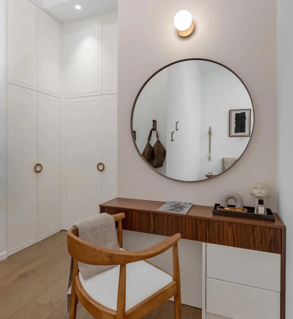 Round Mirror Frames a Minimalist Vanity with Warm Wood Accents