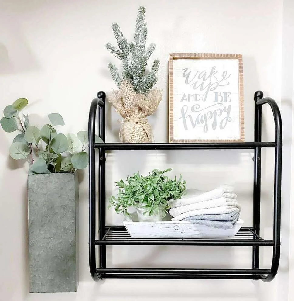 Two-Tiered Metal Shelf Holds Stacked Towels and Greenery