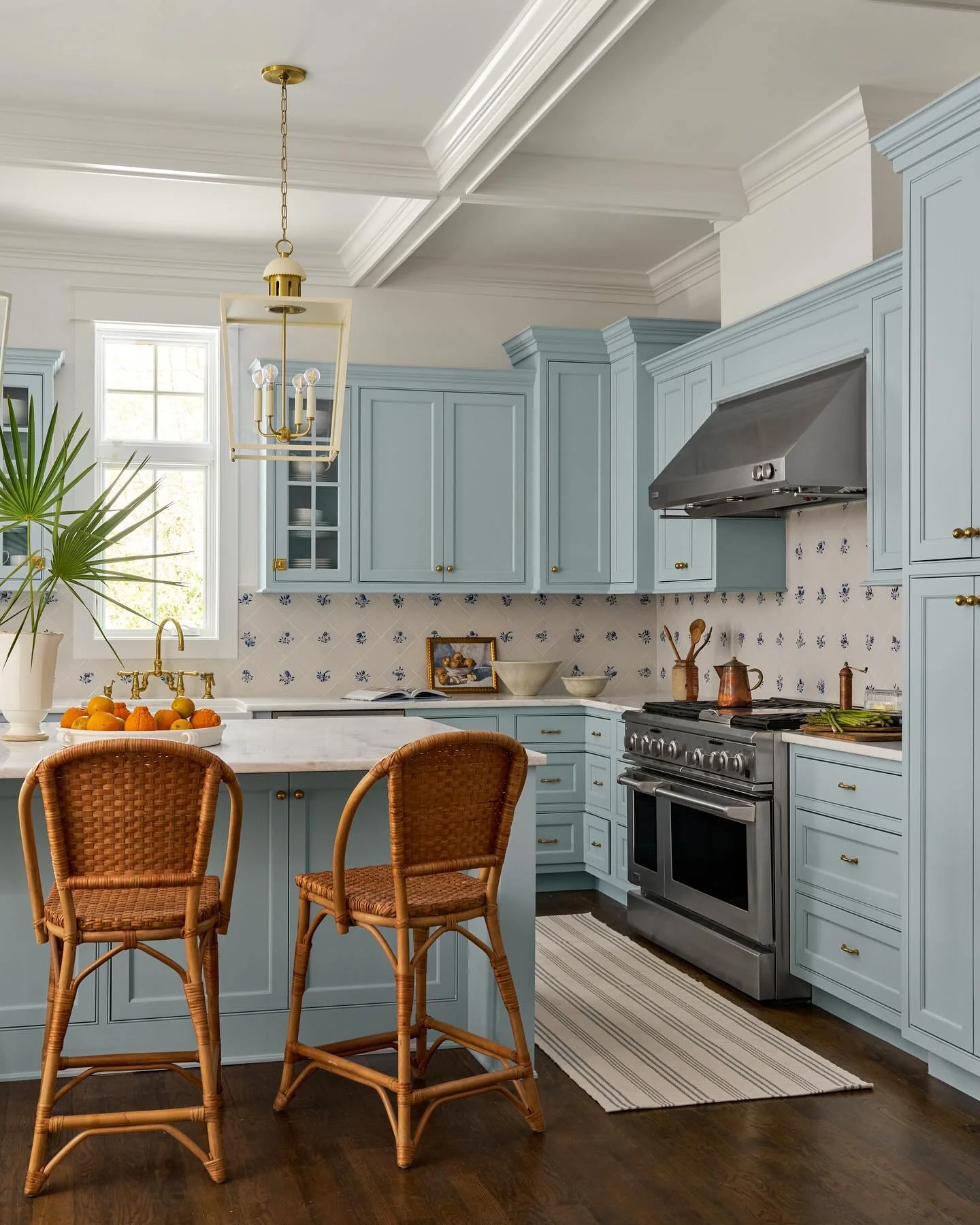 Pale Blue Cabinetry with Brass Hardware Evokes Coastal Calm