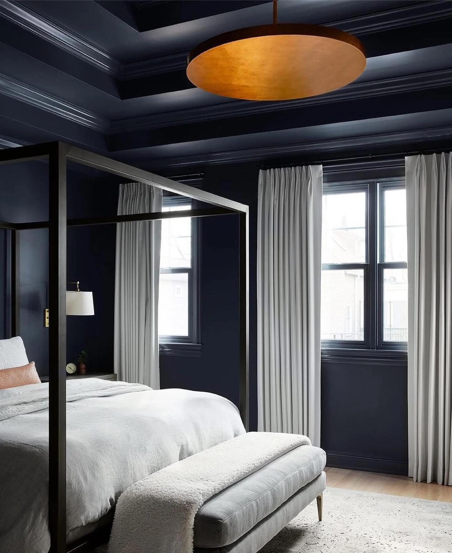 Dark Navy Walls Create a Dramatic Backdrop for a Modern Canopy Bed